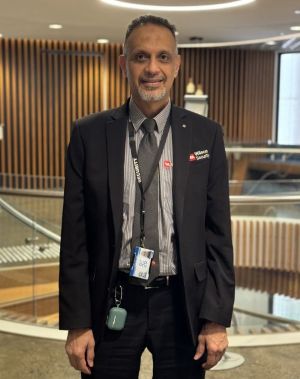 Security guard wearing black and grey clothes with a Wilson Security logo.